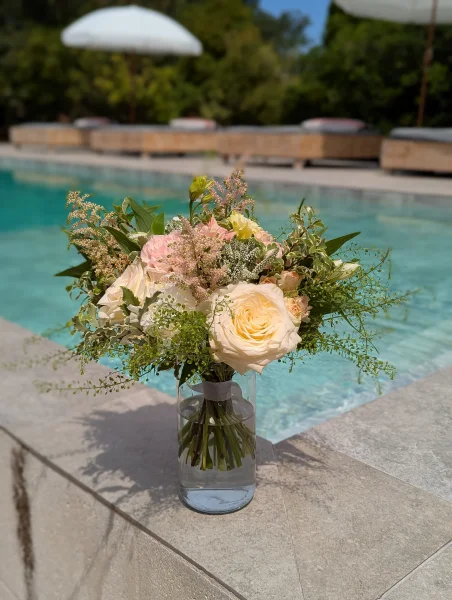 Bouquet de mariée champêtre et romantique avec roses crème, astilbe rose, alstroemeria et feuillage vert frais.