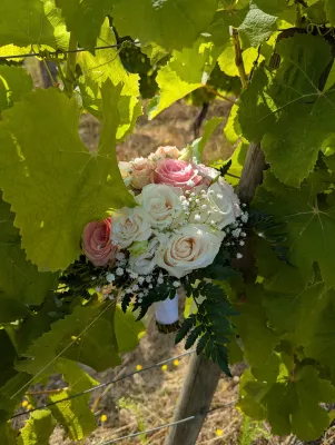 Bouquet de mariée champêtre, composé de roses blanches et roses pâles, avec du gypsophile, pour un mariage estival.