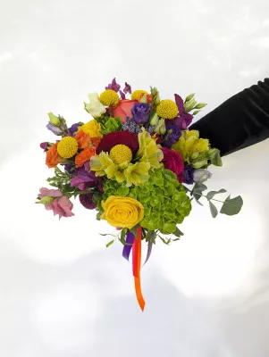 Bouquet de mariée champêtre sophistiqué avec roses orange, chrysanthèmes jaunes et fleurs violettes.