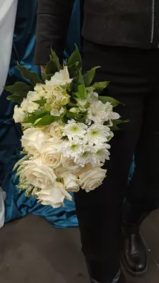 Bouquet de mariée classique entièrement blanc avec roses, chrysanthèmes et alstroemerias pour un mariage d'hiver élégant.