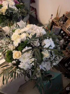 Classic bridal bouquet with white roses, pompon chrysanthemums, and gypsophila for an elegant style.