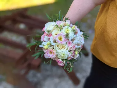 Bouquet de mariée champêtre raffiné avec roses, dahlias et lisianthus aux teintes blanches, roses et vertes pour un mariage.