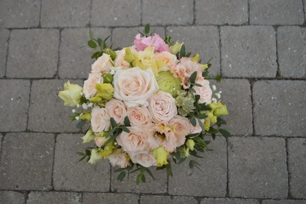 Superbe bouquet de mariée bohème, composé de roses poudrées et jaune crème, lisianthus, eucalyptus et petites fleurs blanches.