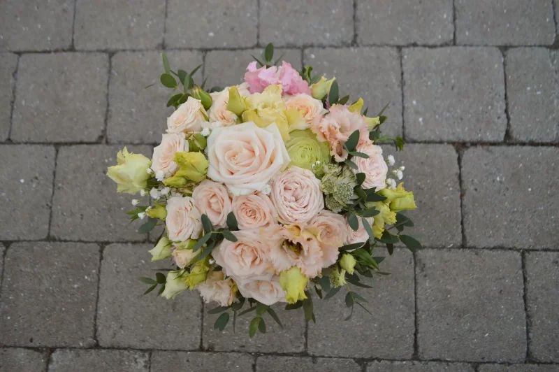 Superbe bouquet de mariée bohème, composé de roses poudrées et jaune crème, lisianthus, eucalyptus et petites fleurs blanches.