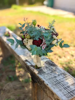 Bouquet de mariée champêtre et élégant avec roses bordeaux, eucalyptus et fleurs crème pour un mariage d'été à Blanquefort.