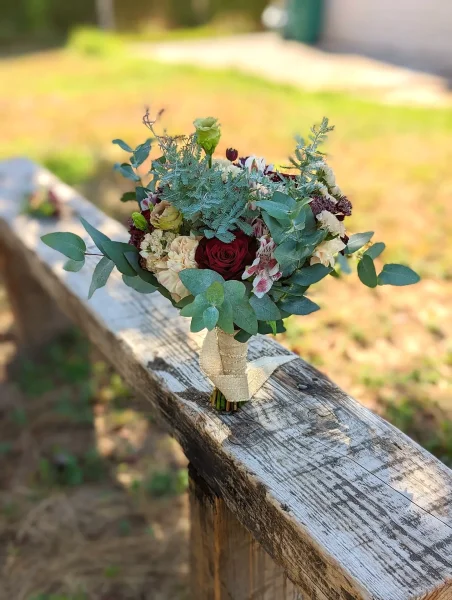 Bouquet de mariée champêtre et élégant avec roses bordeaux, eucalyptus et fleurs crème pour un mariage d'été à Blanquefort.