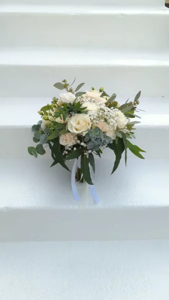 Sophisticated country-style bridal bouquet with white and pale pink roses, gypsophila, and eucalyptus.