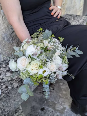 Organic romantic bridal bouquet with cream roses, gypsophila, and eucalyptus for a wedding.
