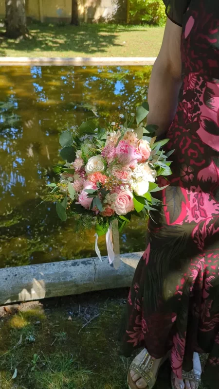 Bouquet de mariée romantique organique avec roses roses et crème, eucalyptus et feuillages verts pour un mariage.