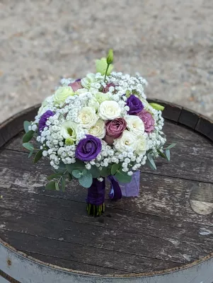 Magnifique bouquet de mariée champêtre avec roses, lisianthus blancs et violets, gypsophile et eucalyptus, mariage de Chloé.
