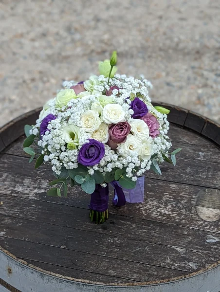 Magnifique bouquet de mariée champêtre avec roses, lisianthus blancs et violets, gypsophile et eucalyptus, mariage de Chloé.