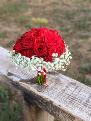 Grand bouquet de mariée classique avec roses rouges intenses et gypsophile blanc pur, pour le mariage de Julie au Caillavet.