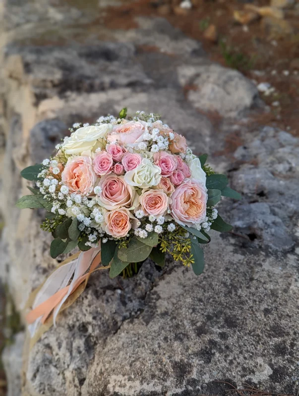 Romantic bridal bouquet composed of white roses, peach roses, gypsophila and fresh green foliage for Leïla.