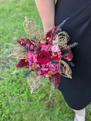 Bouquet de mariée bohème élégant, roses rouges, hortensias magenta, fleurs séchées pêche et feuillage vert olive.