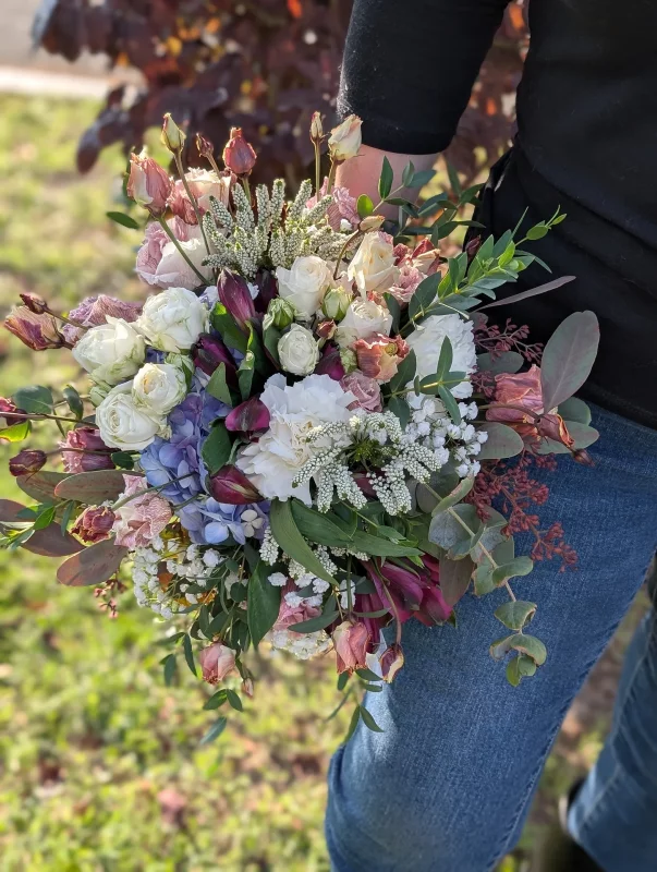 Grand bouquet de mariée bohème aux roses pâles, hortensia bleu et tulipes violettes pour le mariage de Marine.