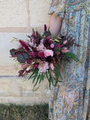Sophisticated rustic bridal bouquet with roses, burgundy hydrangeas, and varied foliage.