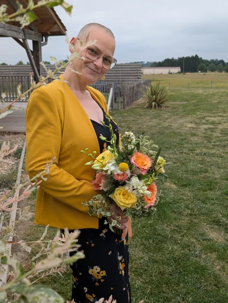Bouquet de mariée champêtre sophistiqué avec roses jaunes, oranges et feuillage panaché.