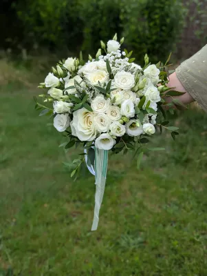 Magnifique bouquet de mariée champêtre pour le mariage de Laetitia, avec roses blanches, lisianthus et feuillage d'eucalyptus.