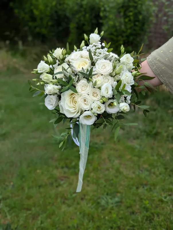 Magnifique bouquet de mariée champêtre pour le mariage de Laetitia, avec roses blanches, lisianthus et feuillage d'eucalyptus.