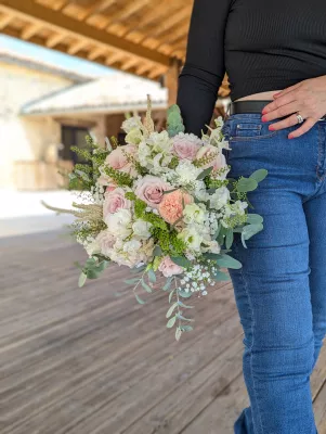 Close-up of an organic romantic bridal bouquet with roses, lisianthus, and green foliage.