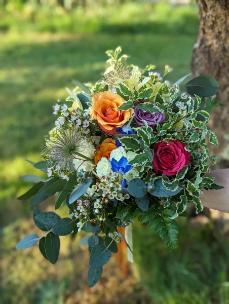 Bouquet de mariée champêtre avec roses orange et rouges, chardon et eucalyptus pour mariage Jennifer à Haux.