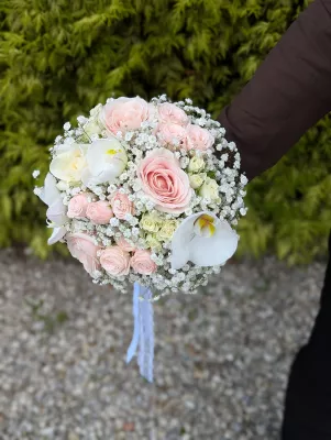 Sublime bouquet de mariée classique avec des roses roses pâles, des orchidées blanches et du gypsophile pour un mariage.