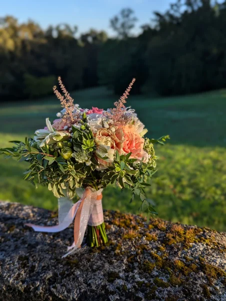Magnifique bouquet de mariée champêtre avec roses pêche, roses poudré, alstroemeria et feuillage pour un mariage d'automne.