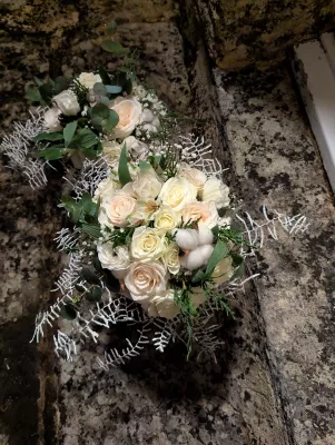 Magnifique bouquet de mariée classique avec roses blanches, roses pêche poudré, eucalyptus et boules de coton pour le mariage Lydie et William.