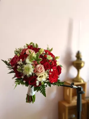 Bouquet de mariée style classique avec roses rouges et roses, astrantia blanche et feuillage, pour un mariage à Arcachon.