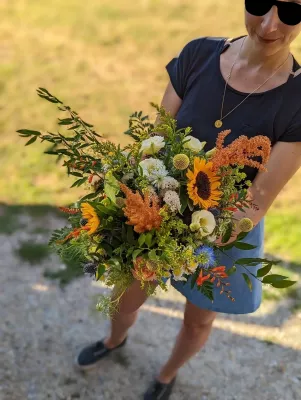 Magnifique bouquet de mariée champêtre avec tournesols, chardons et amarante pour un mariage estival.