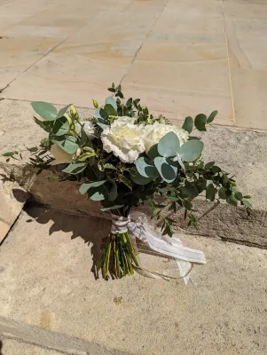 Bouquet de mariée moderne et élégant avec œillets blancs, lisianthus et abondant eucalyptus pour le mariage de Lucie à Pessac.