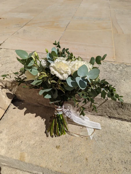 Bouquet de mariée moderne et élégant avec œillets blancs, lisianthus et abondant eucalyptus pour le mariage de Lucie à Pessac.