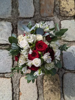Somptueux bouquet de mariée champêtre pour le mariage de Alex, avec roses blanches et rouges, dahlias bordeaux, alstroemeria et eucalyptus.