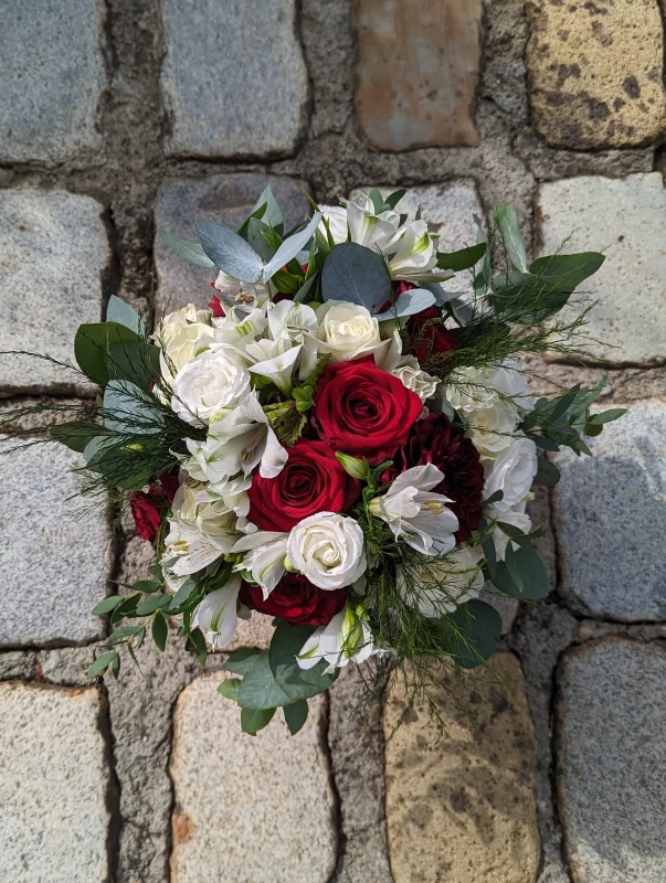 A sumptuous garden-style bridal bouquet for Alex's wedding, featuring white and red roses, burgundy dahlias, alstroemeria, and eucalyptus.