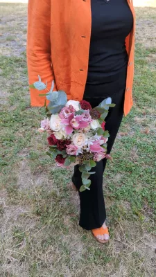 Bouquet de mariée bohème avec roses crème, bordeaux, orchidées roses et eucalyptus pour le mariage de Océane à Tabanac.