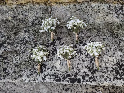Boutonnière champêtre pour mariage, faite de gypsophile et ficelle de jute, un détail élégant et naturel.