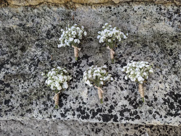Boutonnière champêtre pour mariage, faite de gypsophile et ficelle de jute, un détail élégant et naturel.