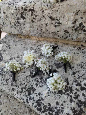 Boutonnières champêtres délicates avec gypsophile et une rose blanche, parfaites pour le marié et les témoins