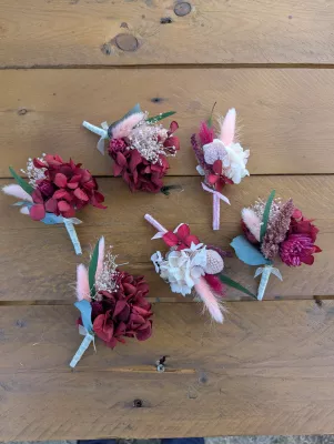 Sophisticated rustic buttonholes with burgundy hydrangeas, pink lagurus, and foliage.