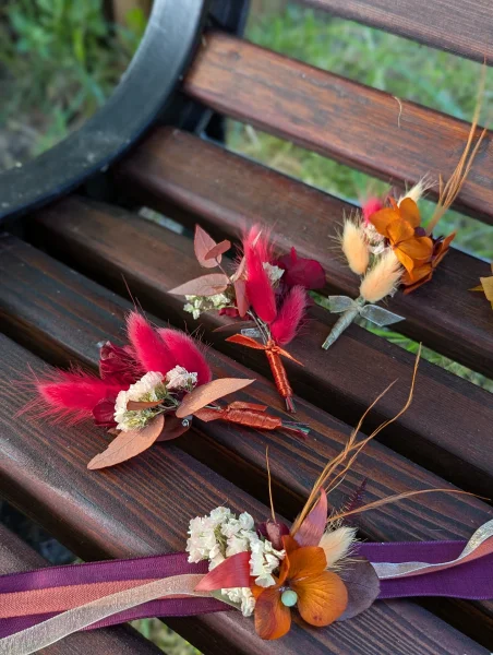Boutonnières de mariage bohème et bracelet assorti avec fleurs séchées, lagurus rouge et mini orchidée orange.