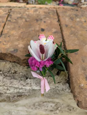 Boutonnière de mariage sur mesure avec une fleur de magnolia, de l'eucalyptus et une délicate fleur en perles artisanale.