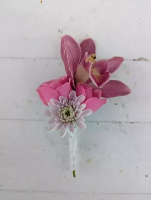 Romantic organic buttonhole with fuchsia pink orchid, pale pink rose, and cream white chrysanthemum.