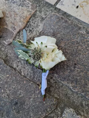 Boutonnière de mariage moderne et champêtre avec rose blanche, chardon et eucalyptus pour le mariage de Lucie à Pessac.