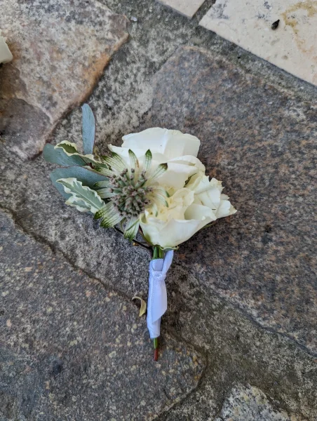 Boutonnière de mariage moderne et champêtre avec rose blanche, chardon et eucalyptus pour le mariage de Lucie à Pessac.