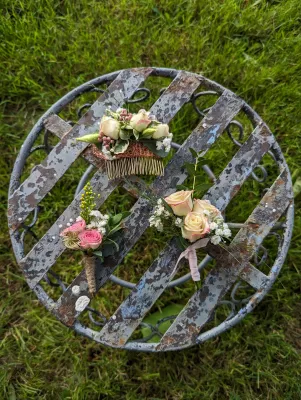 Boutonnière délicate style champêtre avec roses crème, gypsophile et feuillage eucalyptus, parfaite pour un mariage d'été.