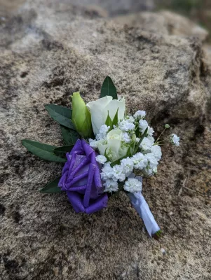 Boutonnière champêtre avec rose violette, rose blanche et gypsophile pour le mariage de Chloé à Cabanac-et-Villagrains.