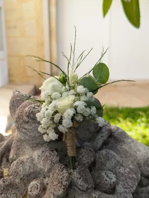 Boutonnière champêtre avec une rose blanche, du gypsophile et des feuilles d'eucalyptus, esprit naturel.