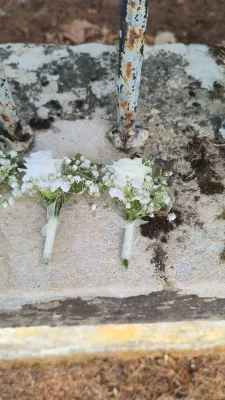 Sophisticated country-style buttonhole with white rose, gypsophila, and eucalyptus for a summer wedding.
