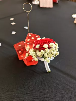 Élégante boutonnière classique avec une rose rouge unique et des accents de gypsophile blanc, parfaite pour un mariage d'automne.