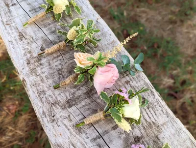 Boutonnière champêtre avec rose blanche, feuillage panaché et astilbe pour le mariage de Karine.
